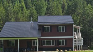En toetages bygning med fladt tag, store vinduer og en overdækket veranda.