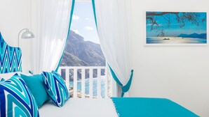A bedroom with a bed, a view of the sea, and a painting on the wall. - Adoro Positano (Positano)