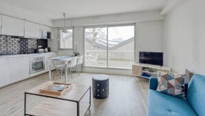 A modern apartment with a kitchen, dining area, and living room.
