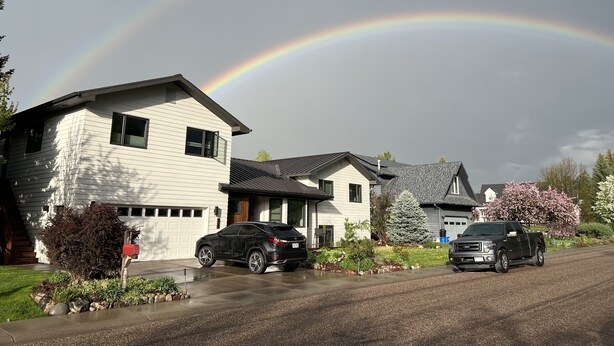 A suburban neighborhood with houses, a driveway, and a rainbow. - Tranquility Base, Modern One-Bedroom Apartment (Carbondale)