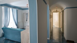 A room with a bed, a radiator, and a hallway leading to another room. - Casa Belmonte (Como)