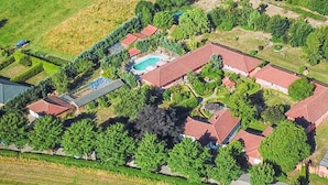 Vista aérea de una zona residencial con varias casas, una piscina y abundante vegetación.