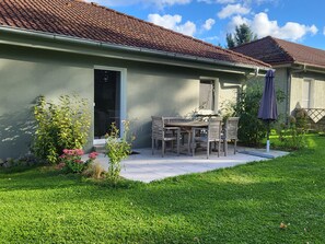 Une maison avec un patio, une table à manger et des chaises.