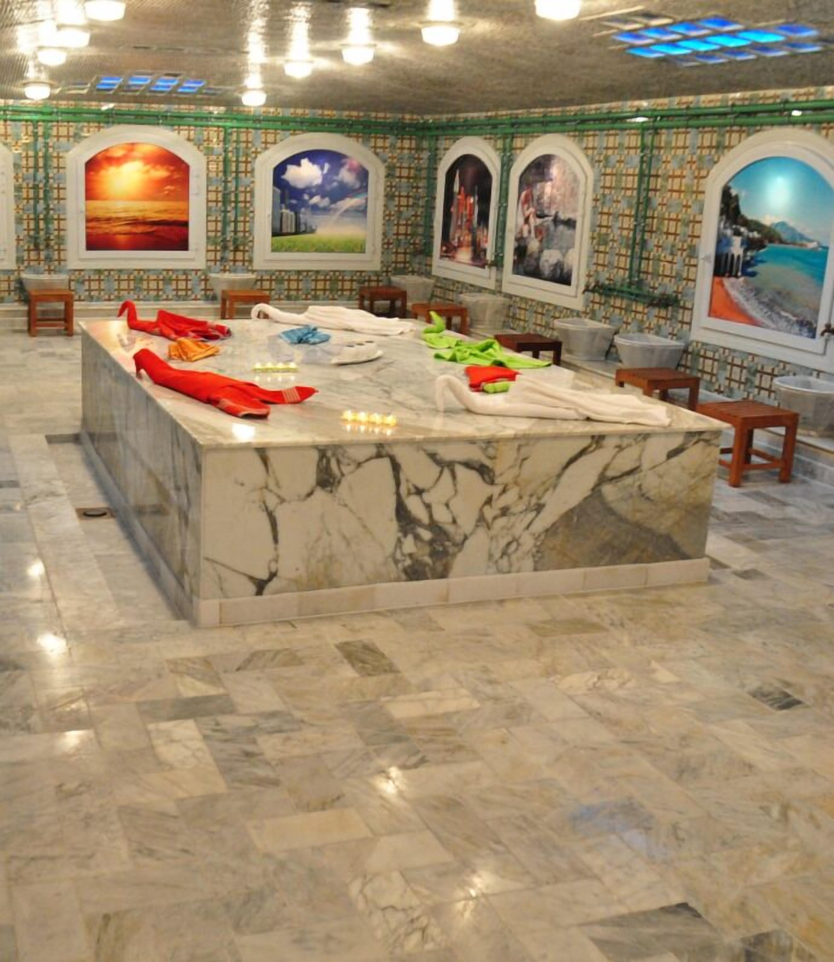 A marble reception desk with artwork on the walls and a tiled floor.