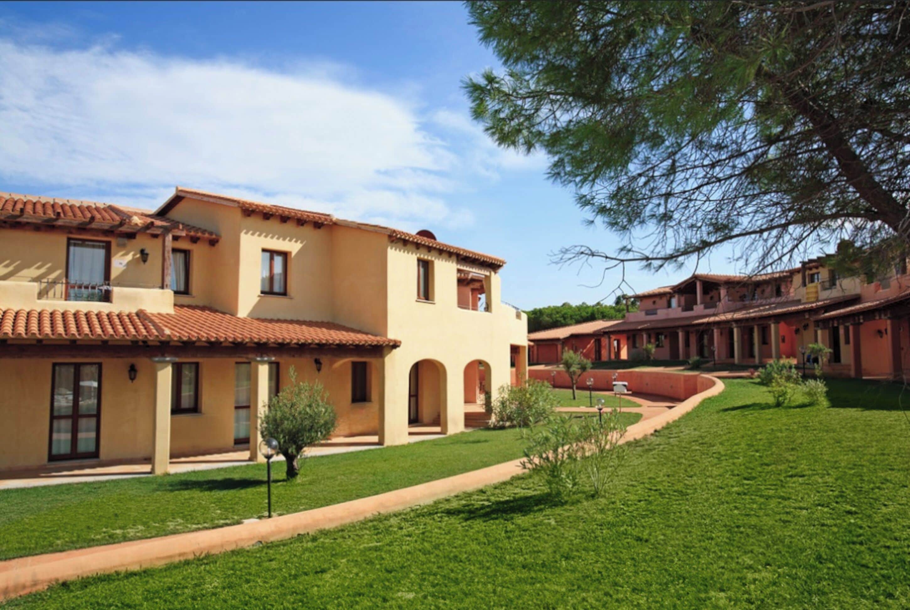 A courtyard with a building featuring a tiled roof and arched windows.