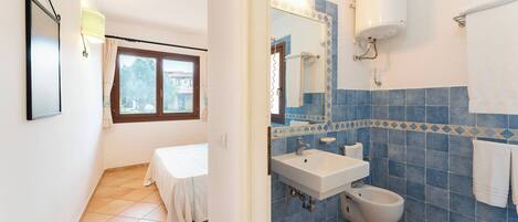 Un baño con lavabo, bidé y espejo.