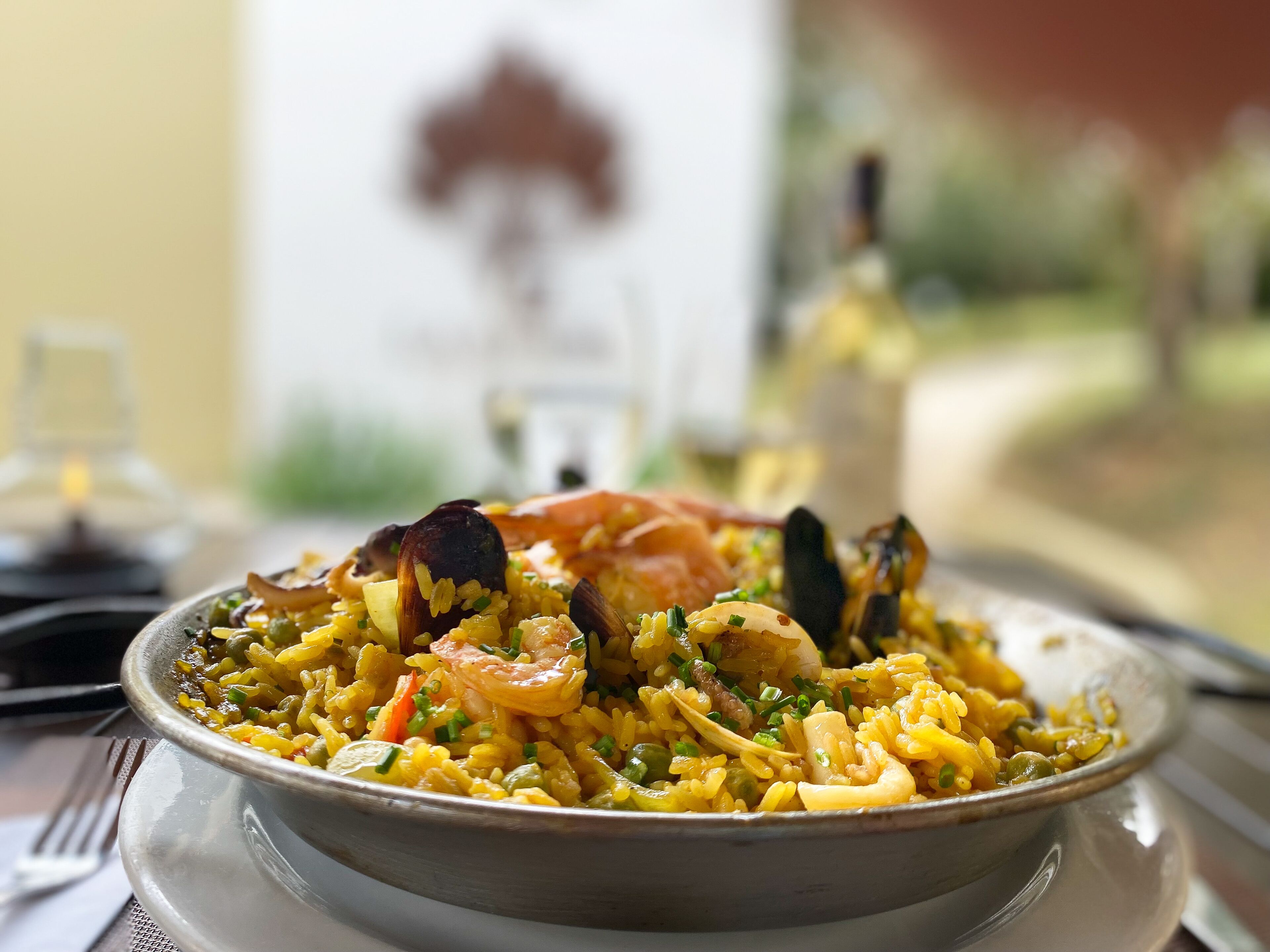 Uma tigela de arroz com camarão e mexilhões, servida num prato.