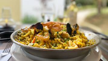 Uma tigela de arroz com camarão e mexilhões, servida num prato.