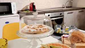 Une cuisine équipée d’un four à micro-ondes, d’un grille-pain, d’un évier et de divers aliments disposés sur le plan de travail.