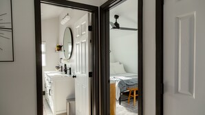A modern bathroom with a white sink, mirror, and white cabinets. - Rainbow Canyon Retreat:  Hot Tub, Fire Pit, Games Room - Sleeps 16+ (Fallbrook)