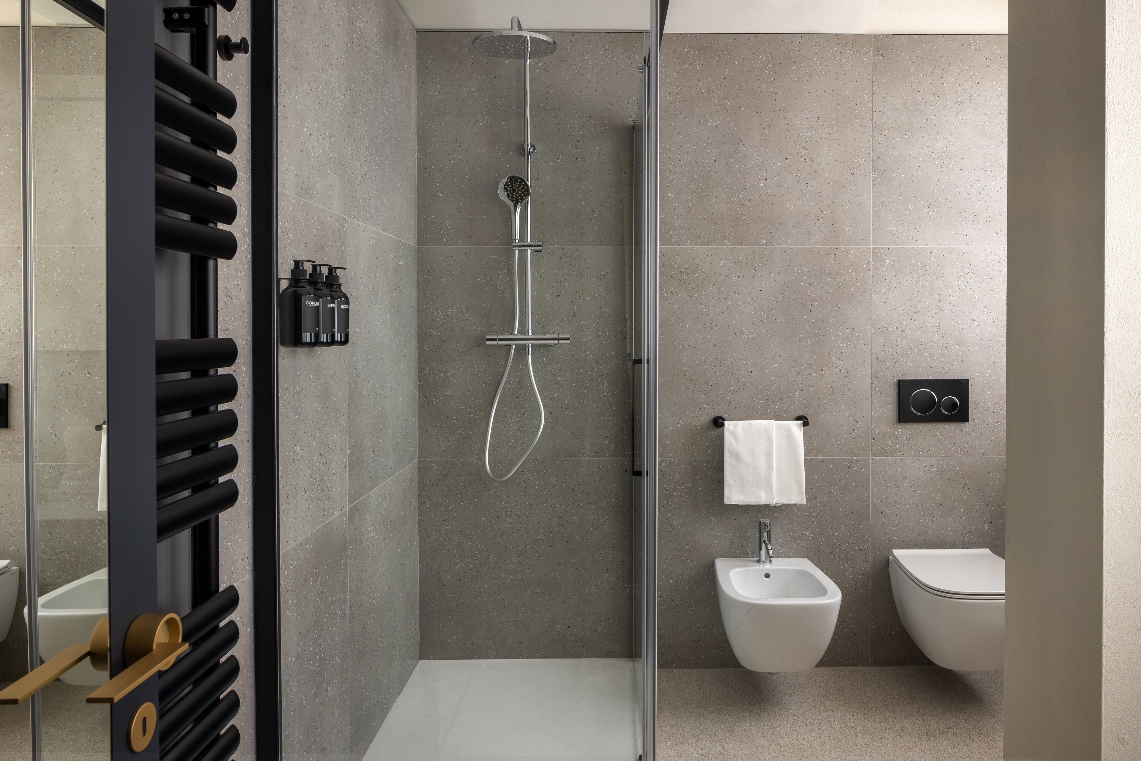 Ein modernes Badezimmer mit Duschkabine aus Glas, einem Bidet und einer Toilette.