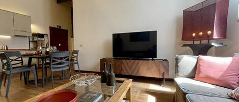 Una sala de estar moderna con televisor, sofá y comedor.