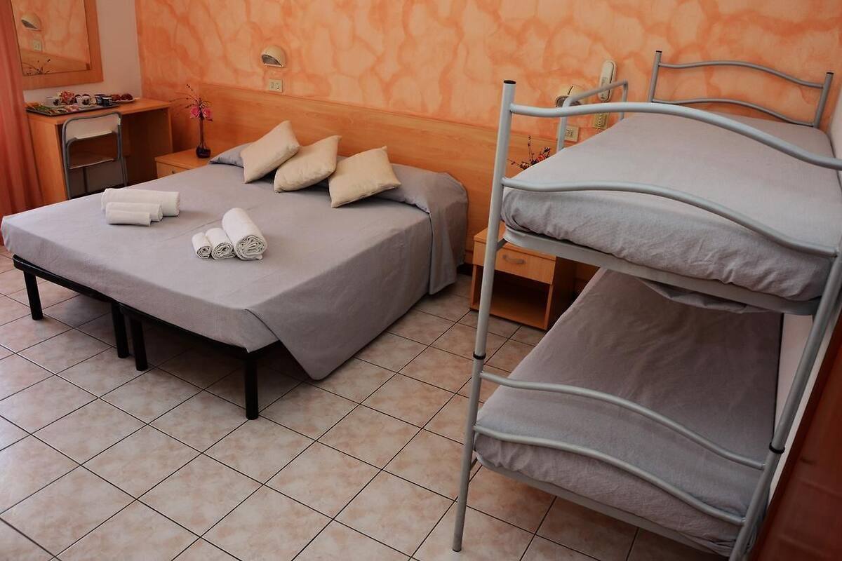 Une chambre d’hôtel avec un lit, un bureau et une chaise.