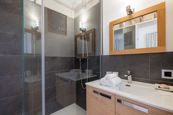 A modern bathroom with a glass shower enclosure, a wooden vanity with a mirror, and a built-in towel rack. - Close to the slopes * View of Mont Blanc (Chamonix-Mont-Blanc)