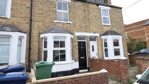 A two-story brick house with a black door, numbered windows, and a small porch area with a green trash bin. - ☀ Sunny, Victorian 2BR Townhouse ☀ Oxford - Pass the Keys (Oxford)