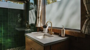 Un baño con un ventanal grande, un lavamanos y un espejo.