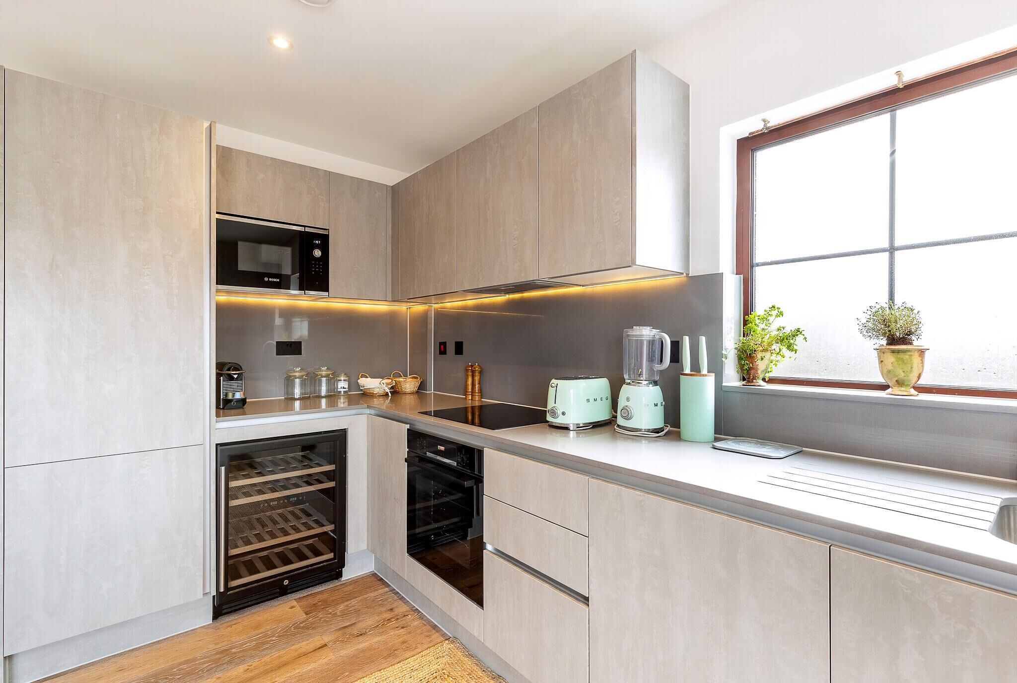 Een moderne keuken met inbouwapparatuur, een raam met uitzicht en een ingebouwde oven.