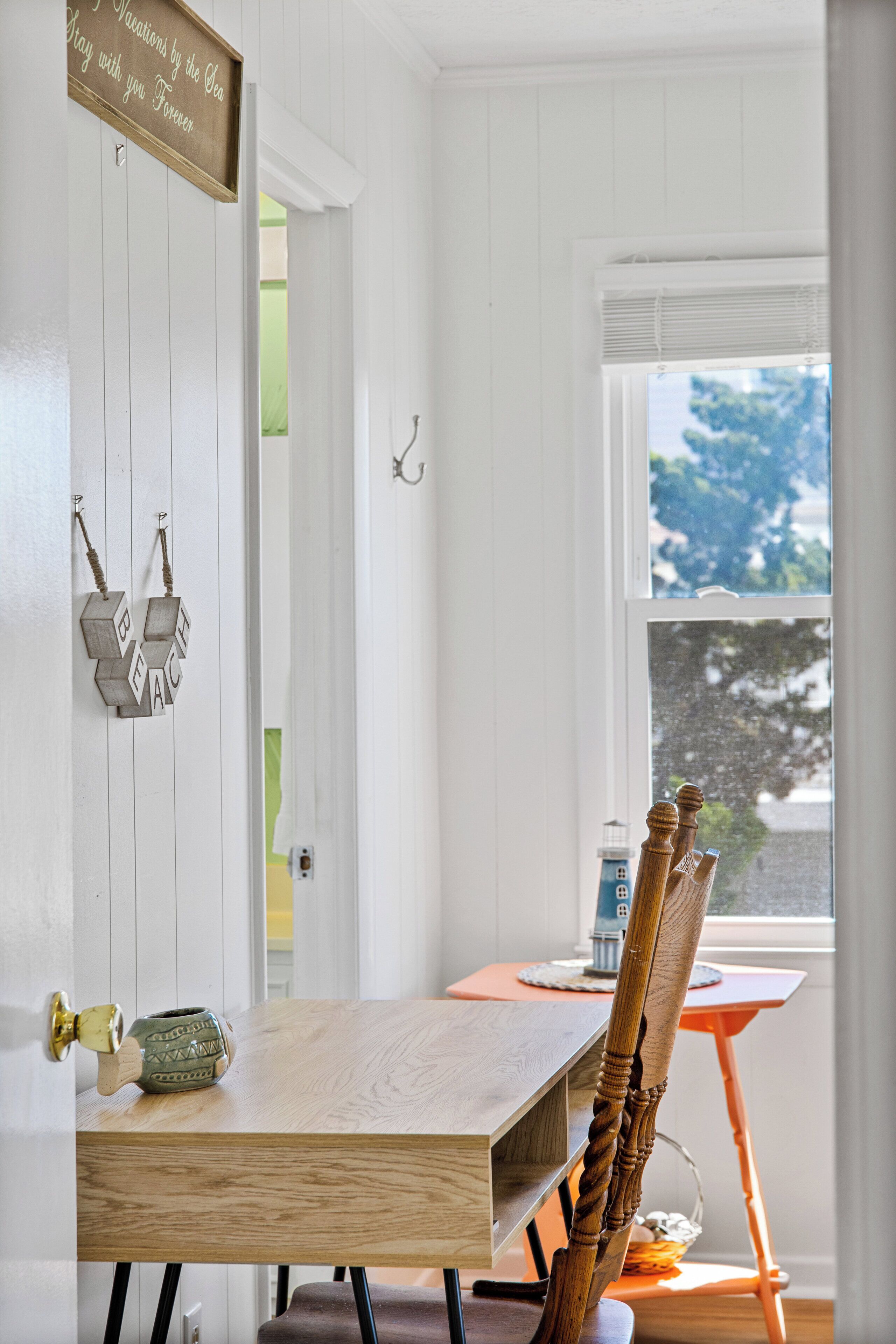 A dining area with a wooden table, chairs, and a window with a view.