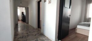 Enter a serene bedroom area with a comfortable bed and a door leading to another room.