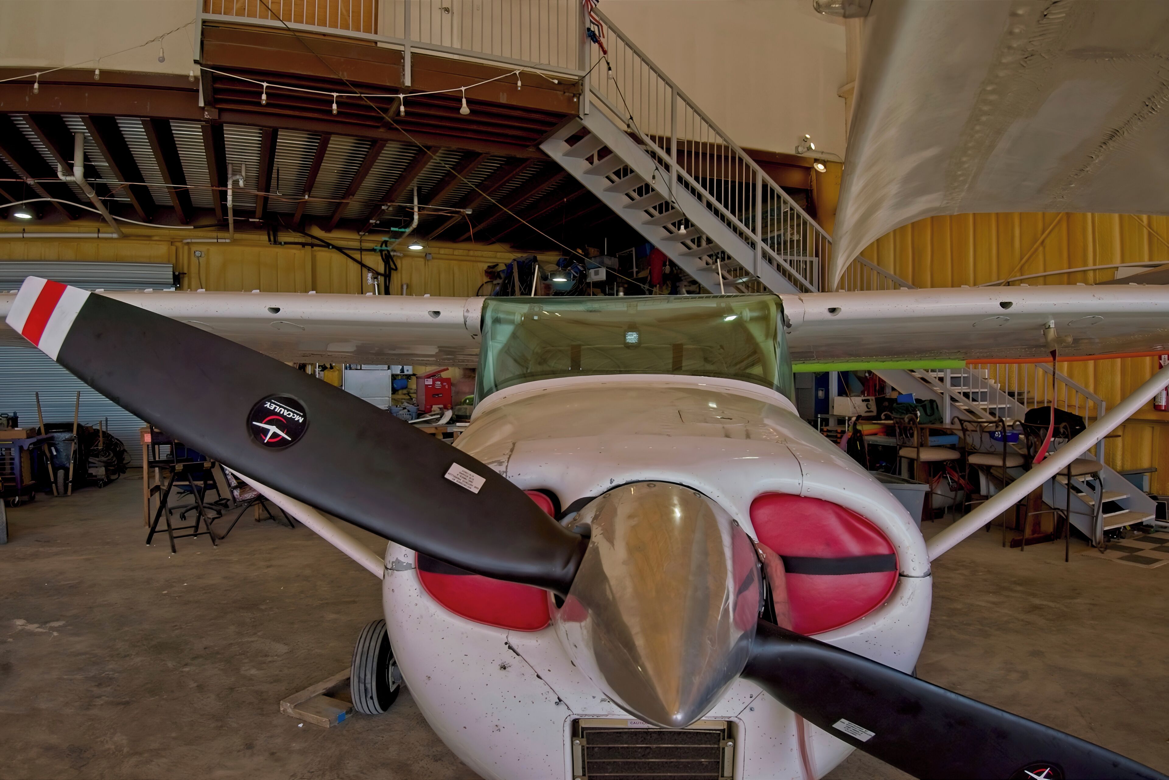 Die Nase eines Flugzeugs und sein Propeller in einer Hangar.