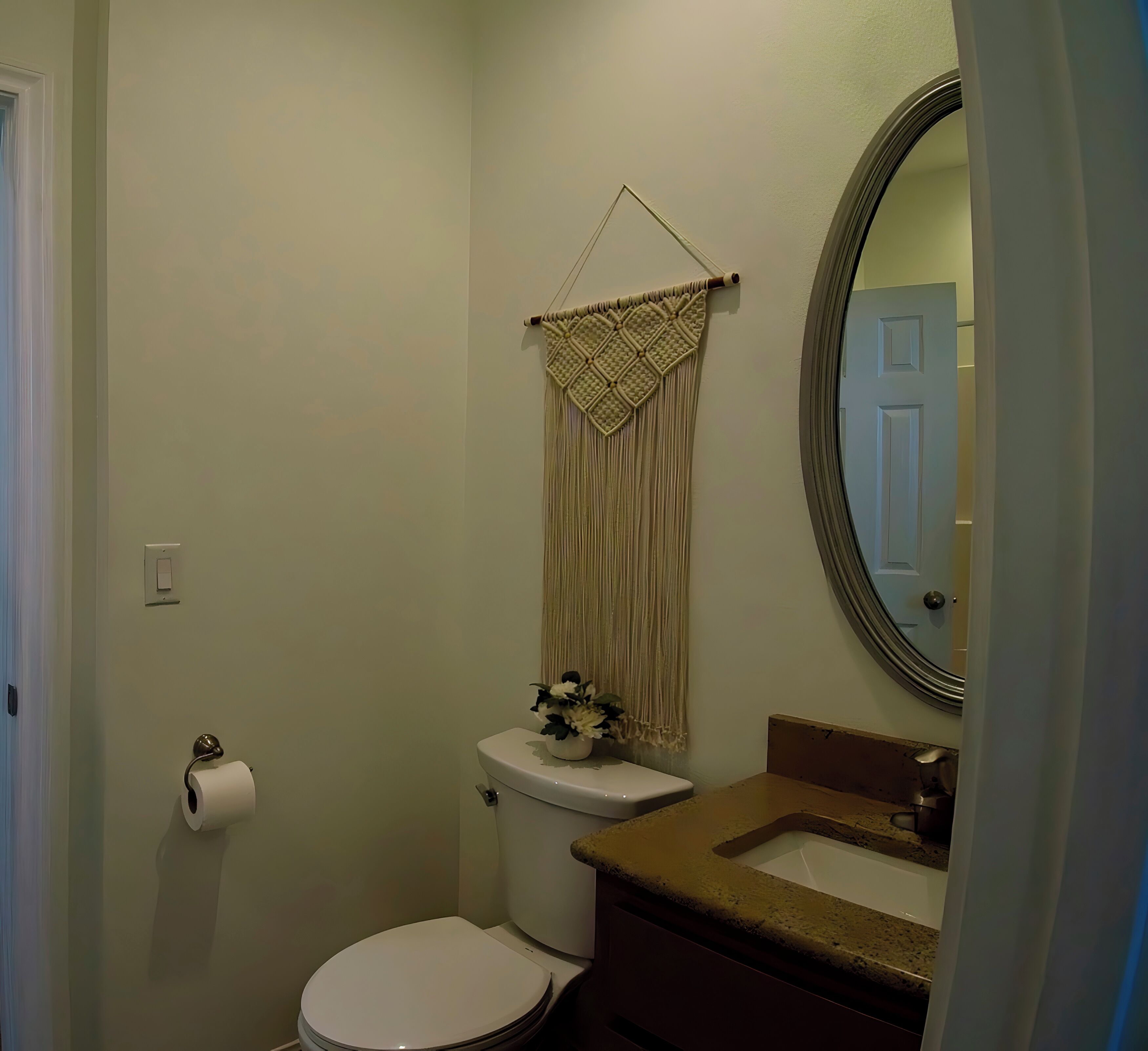 A bathroom with a toilet, sink, and mirror.