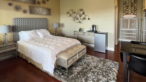 Un dormitorio con cama, mesitas de noche, un escritorio y un ventilador de techo.