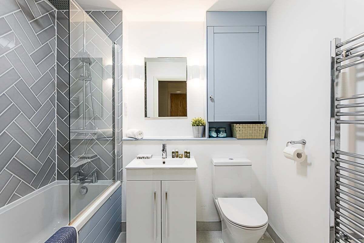 A compact bathroom with a shower, toilet, and sink.