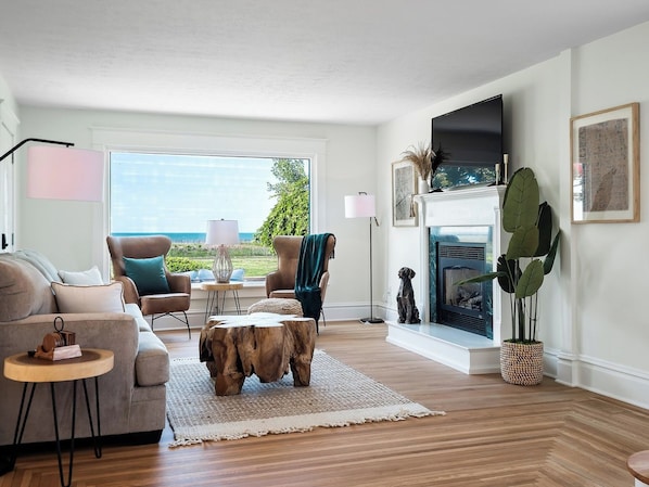 Un salon moderne avec un canapé, un fauteuil, une table basse et une cheminée.