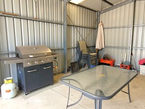Una cocina compacta con estufa a gas, horno pequeño y mesa de vidrio.