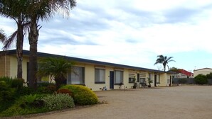 A motel with a simple, single-story structure, featuring a parking lot and some landscaping. - Hamptons, Port Vincent (Port Vincent)