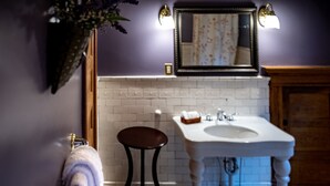 A bathroom with a white sink, a mirror above it, and a wooden cabinet.
