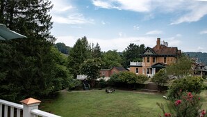 A residential area with a large house, a well-maintained lawn, and a wooden deck.
