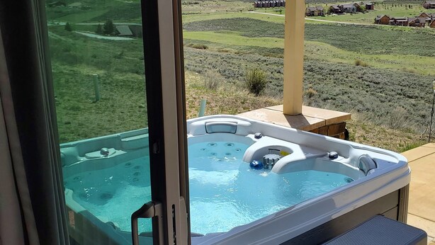 Un jacuzzi con escalones y vistas a un paisaje rural.