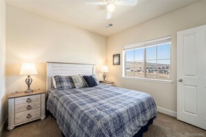 Relax in this serene bedroom with a large bed, two bedside tables, and a window offering a view of the surrounding landscape.