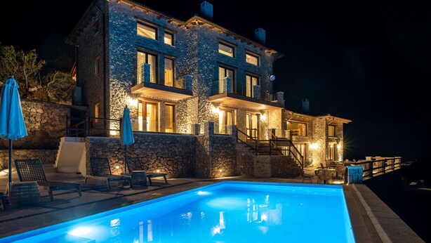 Ein Gebäude aus Stein mit Pool, Außenbereich und einer Treppe zu den oberen Stockwerken.