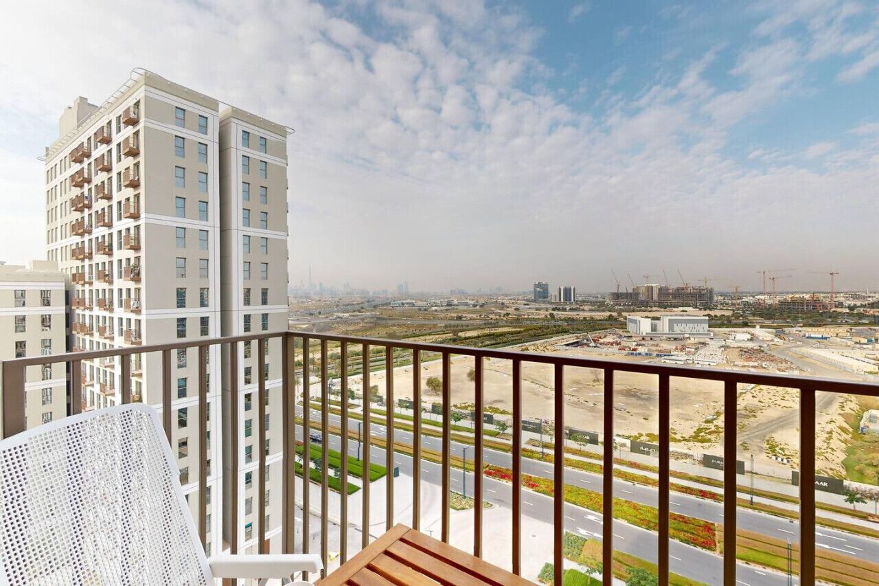 A balcony with a view of a cityscape, including high-rise buildings and construction sites.