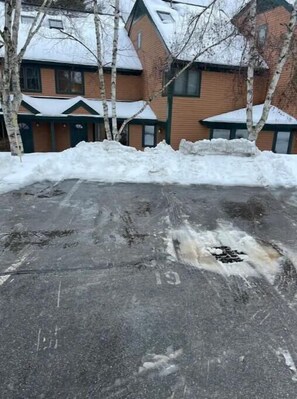 Park your car in the designated area near the building with a brick facade.