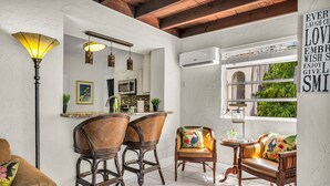 A cozy living area with a dining table, two chairs, a sofa, and a floor lamp. - Birds of Paradise - Historic Spanish Estate (Lake Worth Beach)