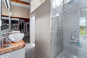 Ein modernes Badezimmer mit einem großen Waschbecken, einem Spiegel und einer Duschkabine.