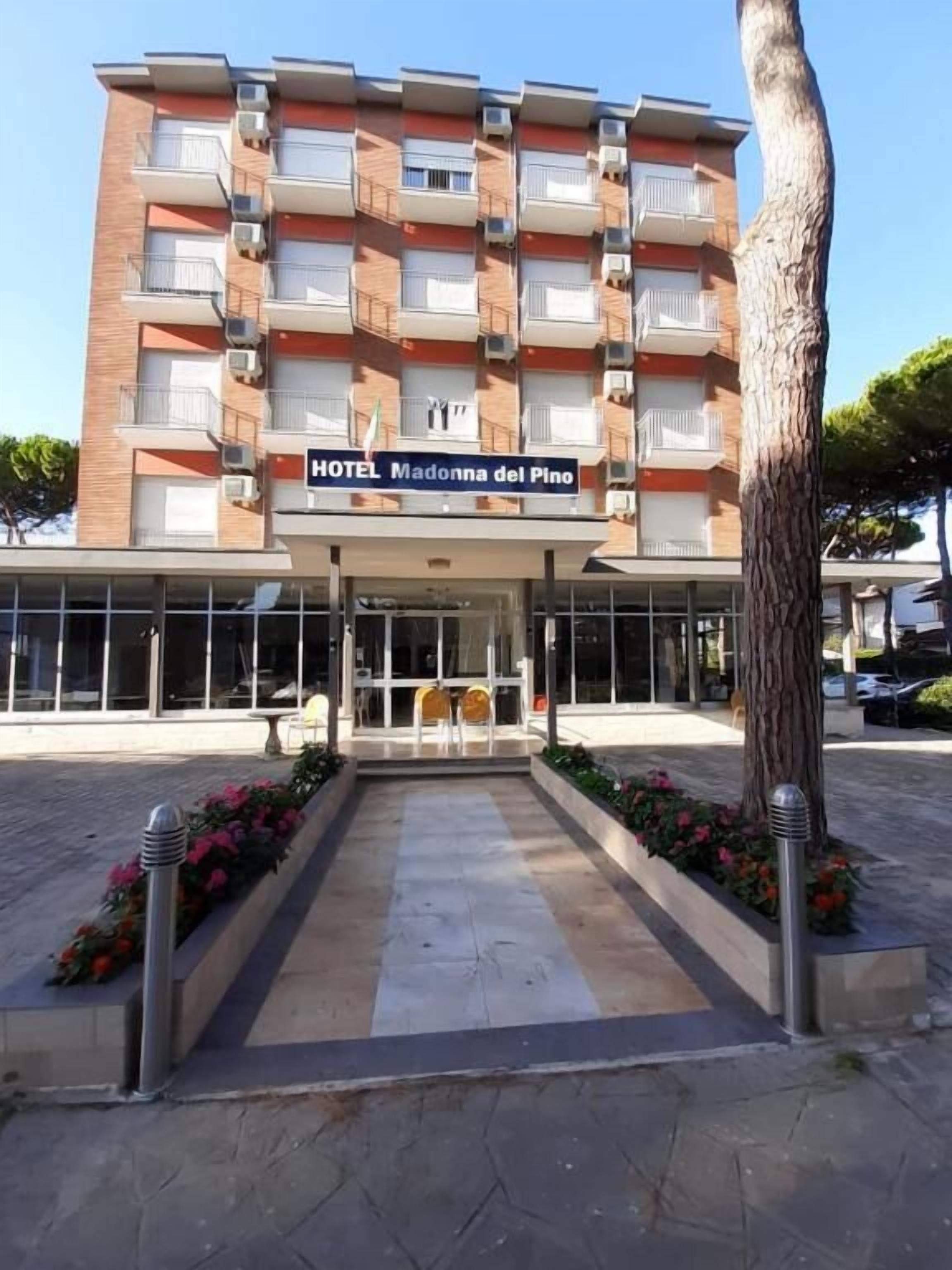 A multi-story hotel building with a sign reading "HOTEL Madonna del Pino".