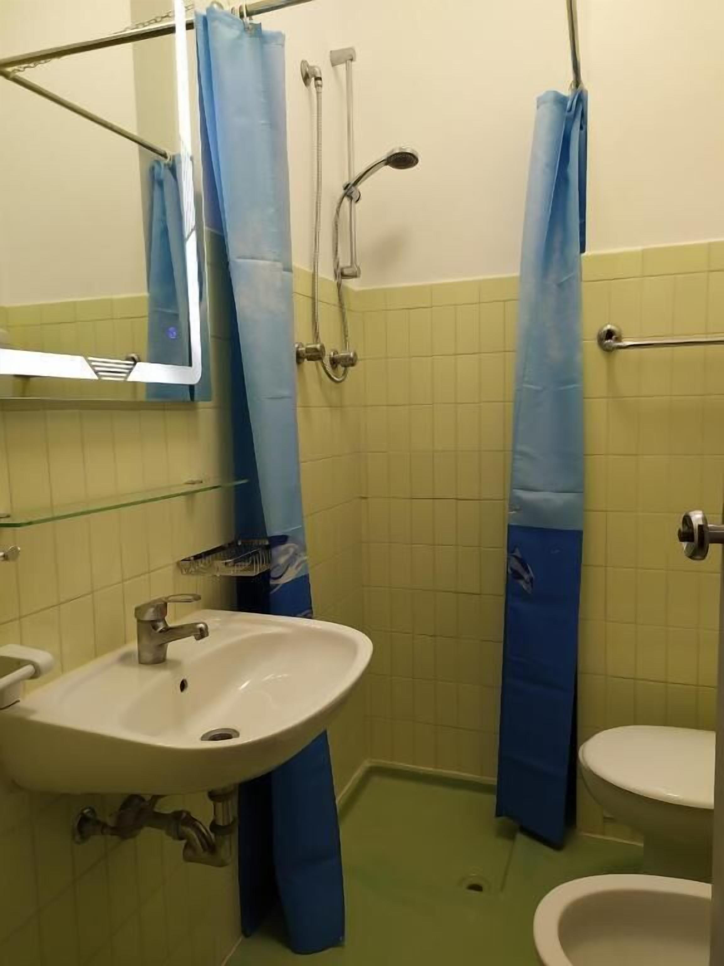 Un baño con lavamanos, inodoro y ducha.