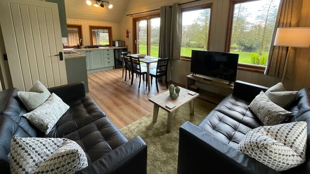 Un salon confortable avec un canapé, une table basse et un téléviseur. Il y a également un coin repas avec une table et des chaises.