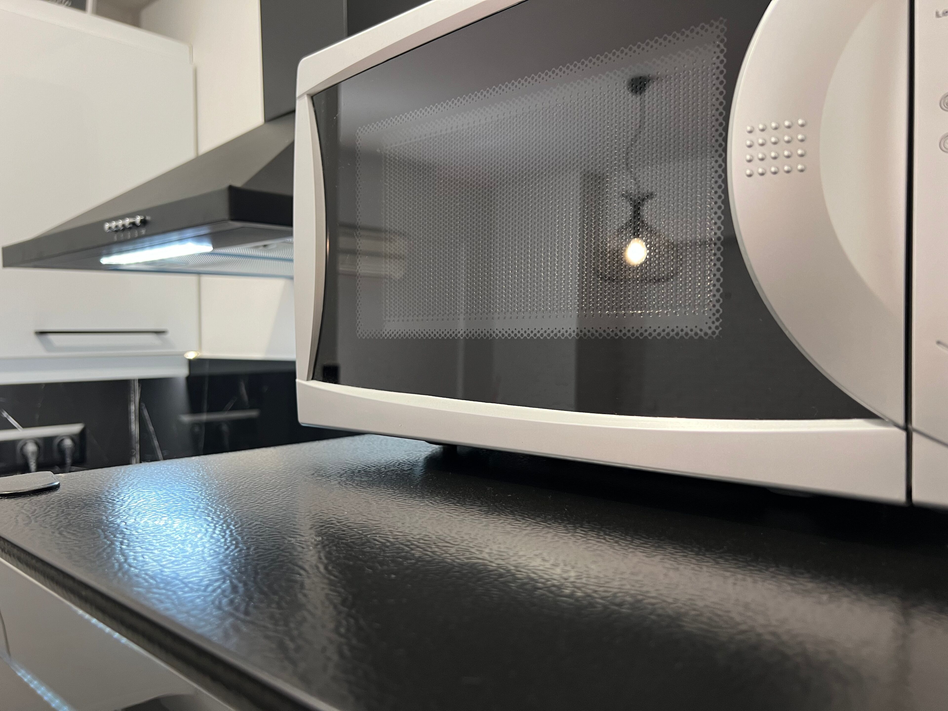 A microwave oven on a black countertop.