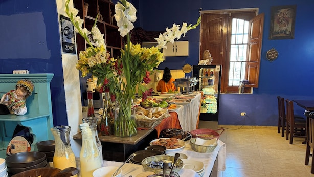 A buffet table with various food items and a vase of flowers.