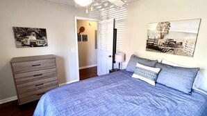 A bedroom with a bed, a dresser, a ceiling fan, and two wall-mounted pictures. - 4 Bed 4 Bath Condo Near Campus! (Auburn)