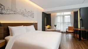 A modern hotel room with a large bed, a cityscape mural, a seating area with a table and chairs, and a view of the city through large windows. - The TianJin eye URcove hotel (Tianjin)