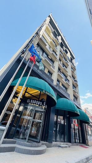 Un hotel de varios pisos con balcones y un cartel que dice 'El Babo's Hotel'.