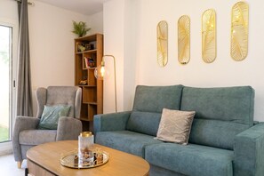 A living room with a sofa, armchair, and a coffee table with decorative items.