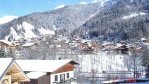 A snow-covered mountain village with wooden chalets and a clear blue sky. - Appartement Camille Bonaventure (Les Contamines-Montjoie)