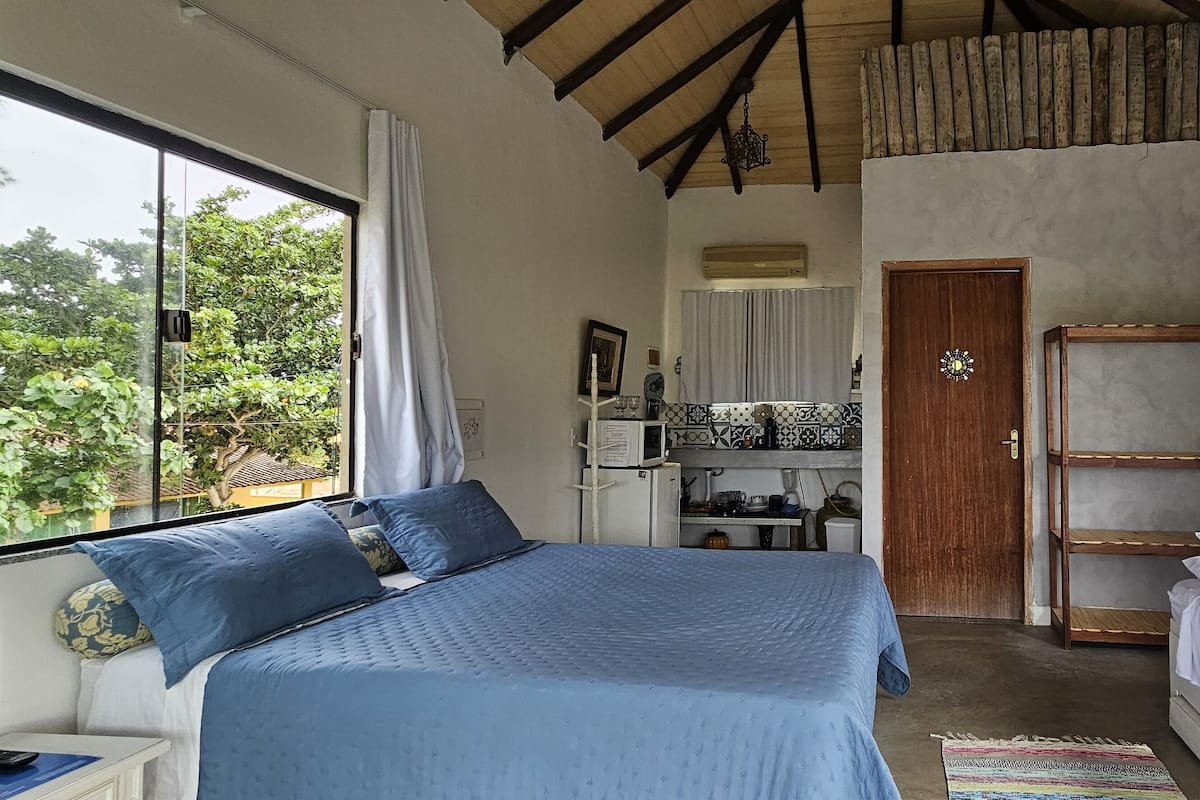 A bedroom with a large bed, a smaller bed, a desk, and a wardrobe.